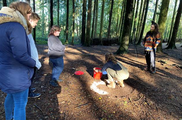 Young people taking part in task in the woods